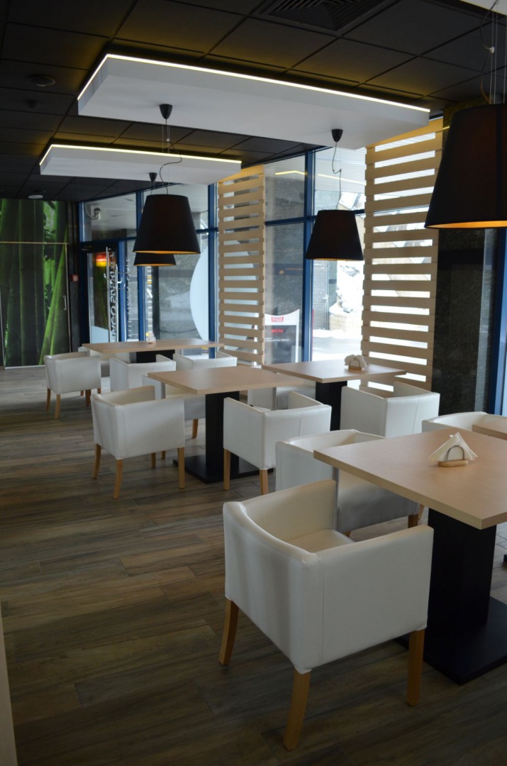 W części pizzerii pojawiają się żyrandole i eleganckie krzesła w kolorze białym. Fot. Archimental 