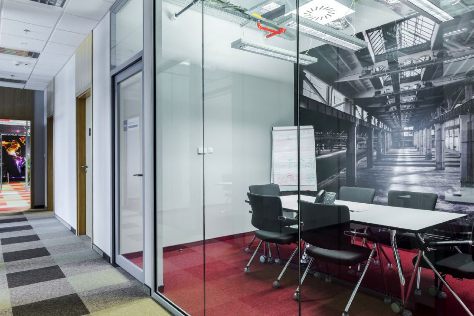 Jednym z wymogów klienta było stworzenie dużej ilości meetingroom-ów oraz co najmniej dwóch sal konferencyjnych z możliwością łączenia w jedną. Takie dwie sale konferencyjne zlokalizowane zostały w strefie wejścia i dodatkowo zaakcentowane designerskimi lampami marki VIBIA. Fot. Ewa Motylewska Photography