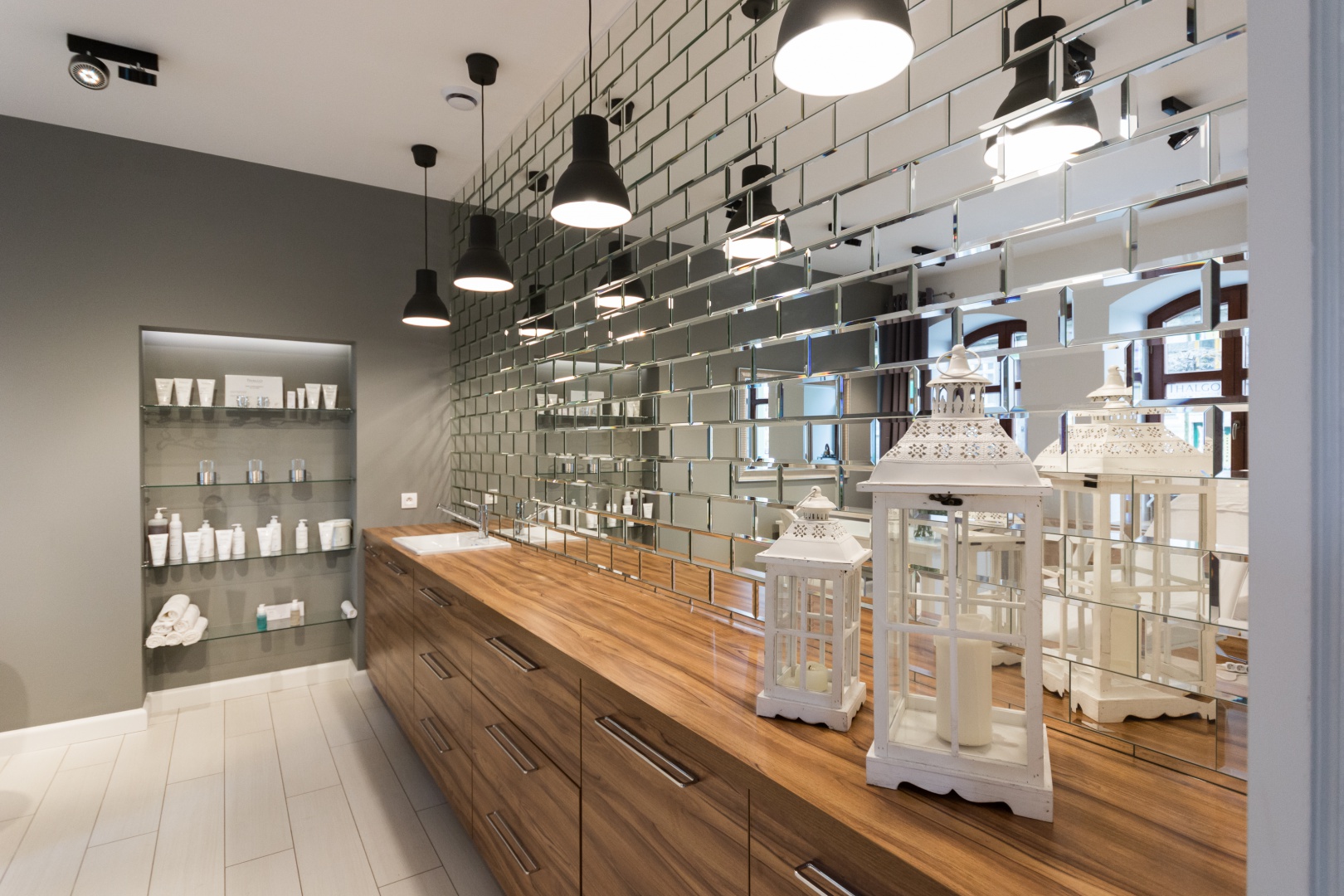 Jedna ze ścian pomieszczenia kosmetycznego pokryta została lustrzanymi cegiełkami, wykonanymi na zamówienie przez szklarza. Nawiązują one formą do autentycznej cegły z pomieszczenia fryzjerskiego. Fot. Wojciech Komada