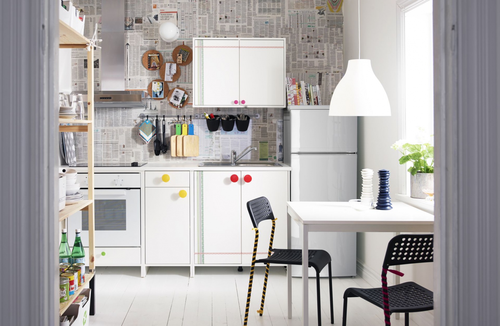 Biała kuchnia z niewielkim, trzyosobowym stołem, który ulokowano tuż pod oknem. Fot. IKEA.jpg
