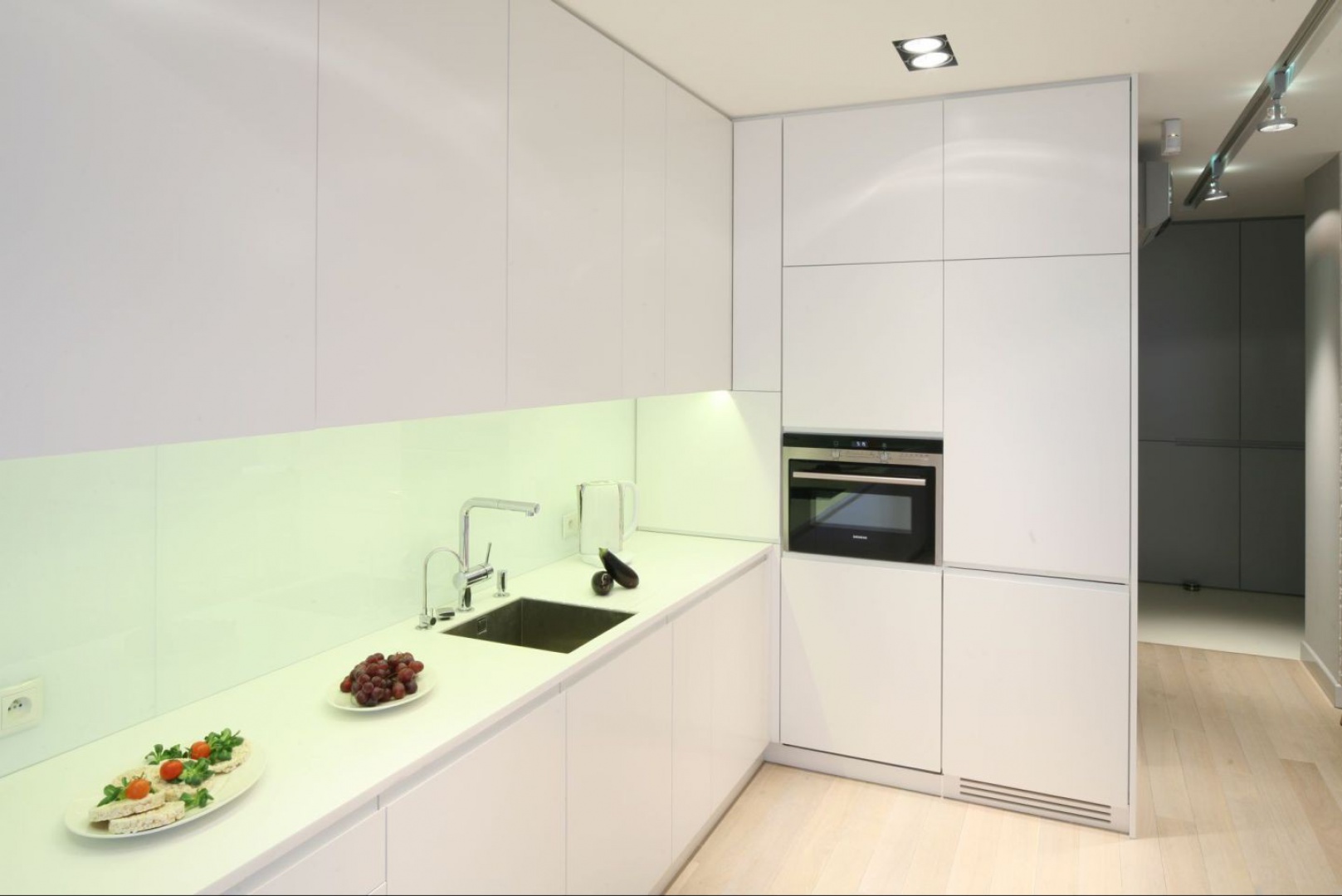 Pomimo eleganckiego i zarazem powściągliwego charakteru zabudowa kuchenna oferuje wiele praktycznych i nowoczesnych funkcji. Projekt Hola Design. Fot. Archiconnect.jpg